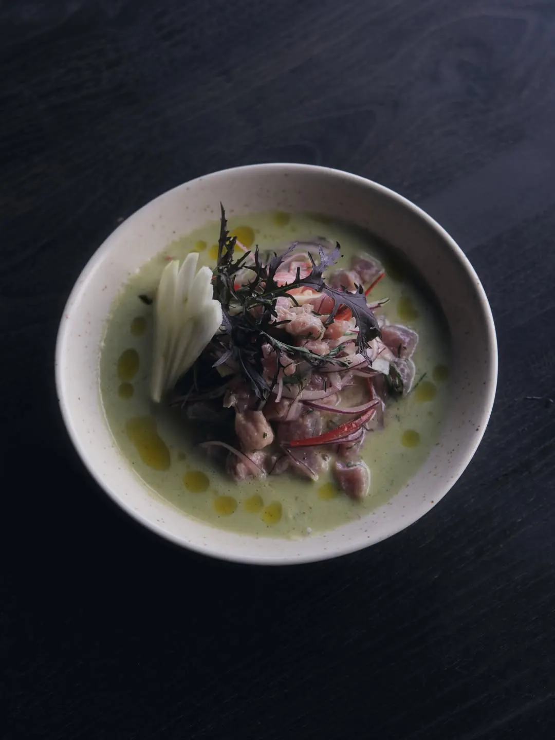 Plato de mariscos en caldo verde, servido en cerámica
