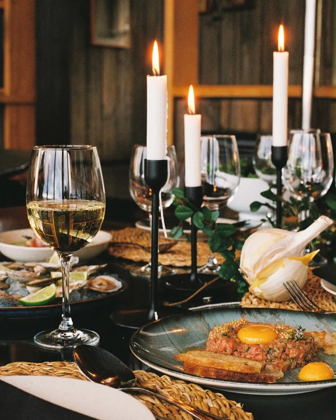 Mesa larga con velas, copas y platos del archipiélago