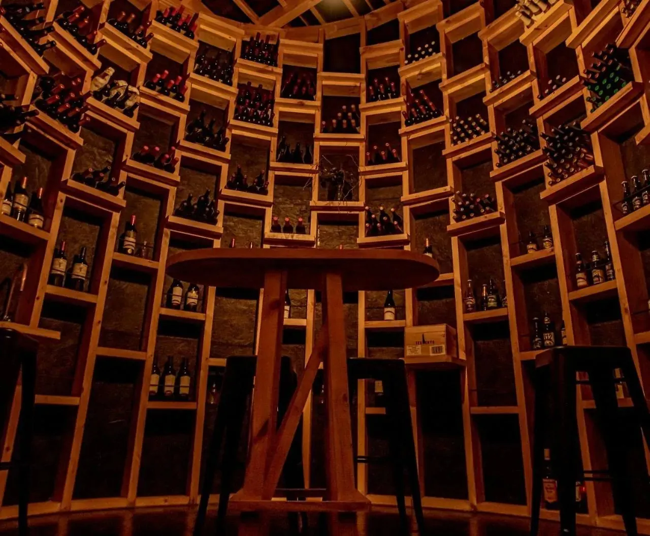 La cava: muros curvos de nichos de madera llenos de botellas