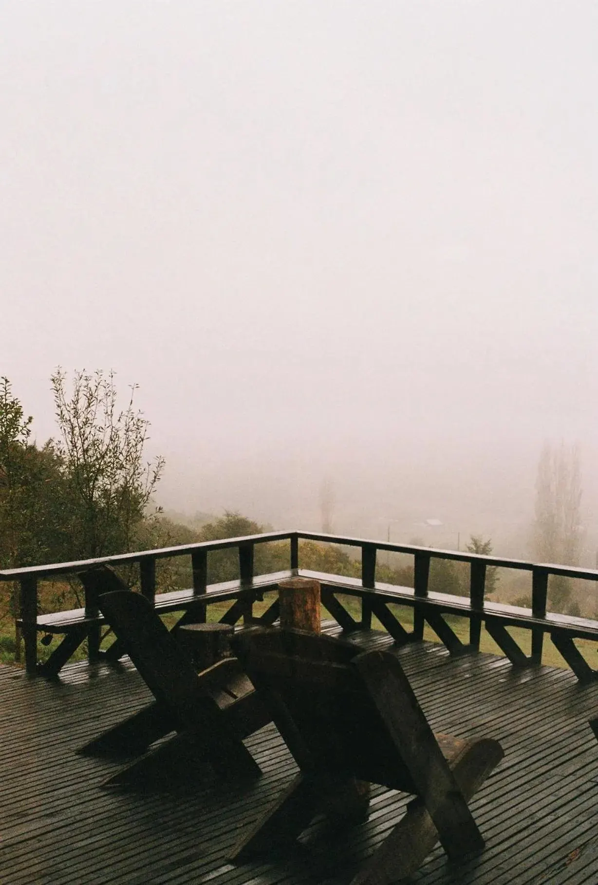 Terraza de madera con sillas frente a la niebla