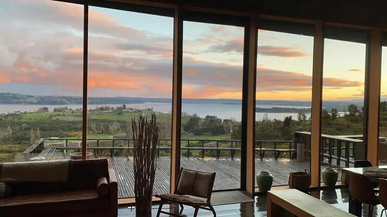 Sala de estar con ventanales hacia el mar al atardecer